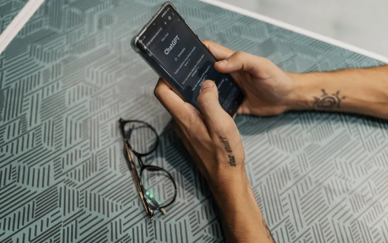Phone open on ChatGPT, where AEO services in Pakistan aim to get local businesses recommended